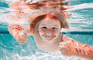 Child swim under water in sea. Kid swimming in pool underwater. Happy boy swims in sea underwater. Children in water.