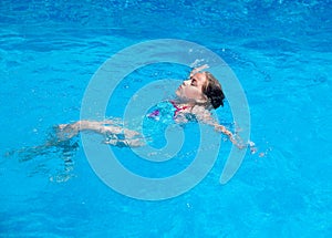 Child swimming backstroke