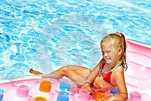 Child swimming on beach mattress.