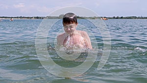 A Child Swimming, Drowning, Splashing Hands, Diving Under Water on the Beach.