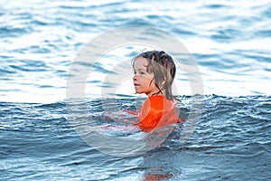 Child swimming in ocean sea. Kid boy having fun on the beach. Kids summer vacation. Summer resort.