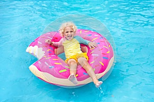 Child in swimming pool on donut float