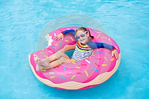 Child in swimming pool on donut float