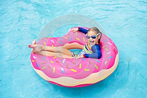 Child in swimming pool on donut float