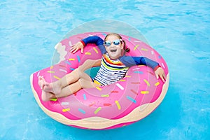 Child in swimming pool on donut float