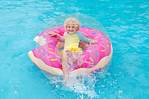 Child in swimming pool on donut float