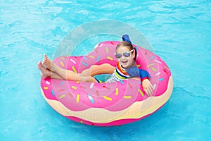 Child in swimming pool on donut float