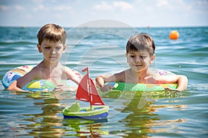 Child in swimming pool floating on toy ring. Kids swim. Colorful rainbow float for young kids. Little boy having fun on family