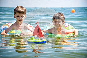 Child in swimming pool floating on toy ring. Kids swim. Colorful rainbow float for young kids. Little boy having fun on family