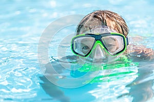 Child swimming in a pool with goggles on