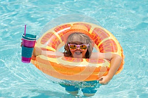 Child in swimming pool on inflatable float ring. Water toy, healthy outdoor sport activity for children. Kids beach fun