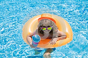 Child in swimming pool on inflatable float ring. Water toy, healthy outdoor sport activity for children. Kids beach fun