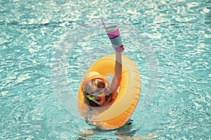 Child in swimming pool on inflatable float ring. Water toy, healthy outdoor sport activity for children. Kids beach fun