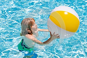 Child in swimming pool on inflatable ring. Kid swim with orange float. Water toy, healthy outdoor sport activity for