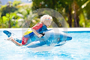 Child in swimming pool. Kid on inflatable float