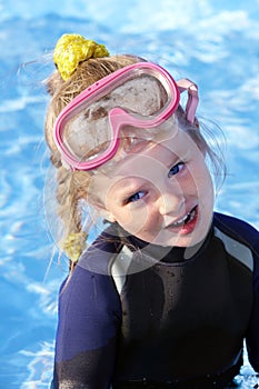 Child in swimming pool learning snorkeling.