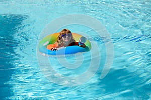 Child in swimming pool playing in water, copy space. Vacation and traveling with kids. Children play outdoors in summer