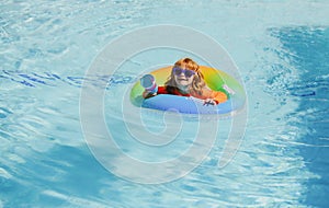 Child in swimming pool playing in water, copy space. Vacation and traveling with kids. Children play outdoors in summer