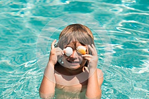 Child in swimming pool playing in water. Vacation and traveling with kids. Children play outdoors in summer. Covered