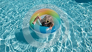 Child in swimming pool playing in water. Vacation and traveling with kids. Children play outdoors in summer. Kid with