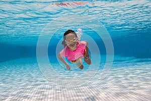 Child in swimming pool on ring toy. Kids swim