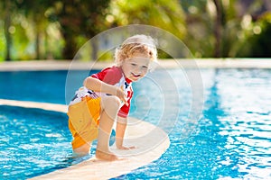 Child in swimming pool. Summer vacation with kids.