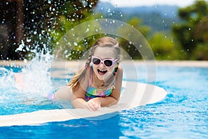 Child in swimming pool. Summer vacation with kids.