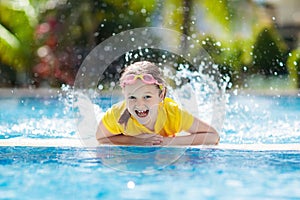 Child in swimming pool. Summer vacation with kids