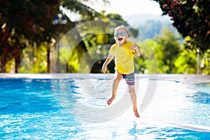 Child in swimming pool. Summer vacation with kids