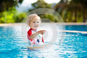 Child in swimming pool. Summer vacation with kids