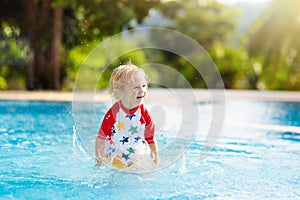 Child in swimming pool. Summer vacation with kids