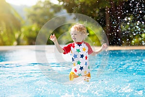 Child in swimming pool. Summer vacation with kids