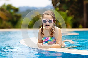 Child in swimming pool. Summer vacation with kids