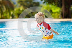 Child in swimming pool. Summer vacation with kids