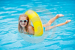 Child in swimming pool on toy ring. Kids swim