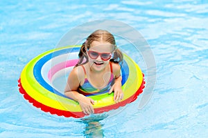 Child in swimming pool on toy ring. Kids swim