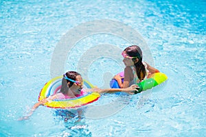 Child in swimming pool on toy ring. Kids swim