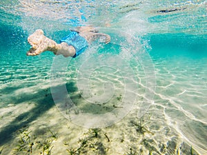 Child swimming seen from behind