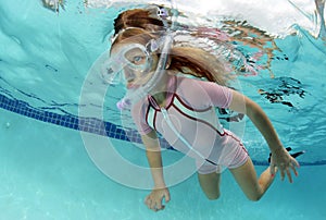 Child swimming underwater in pool