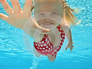 Child swimming underwater in pool