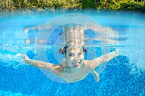 Child swims in pool underwater