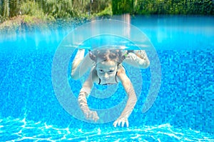 Child swims in pool underwater