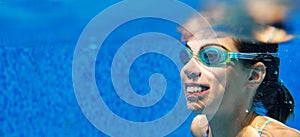Child swims in pool underwater, girl in goggles has fun