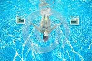 Child swims in pool underwater, girl has fun in water