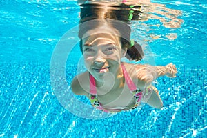 Child swims in pool underwater, happy active girl dives and has fun under water, kid fitness and sport