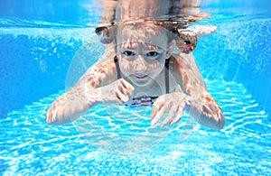 Child swims in pool underwater, happy active girl has fun