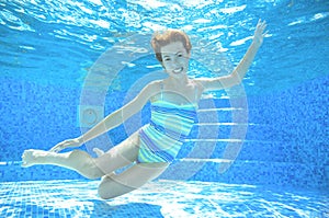 Child swims in pool underwater, happy active girl has fun under water, kid sport