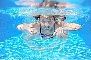 Child swims in pool underwater, happy active girl has fun under water, kid sport