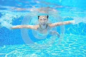 Child swims in pool underwater, happy active girl has fun under water, kid sport