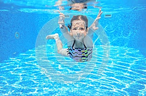 Child swims in pool underwater, happy active girl has fun under water, kid sport